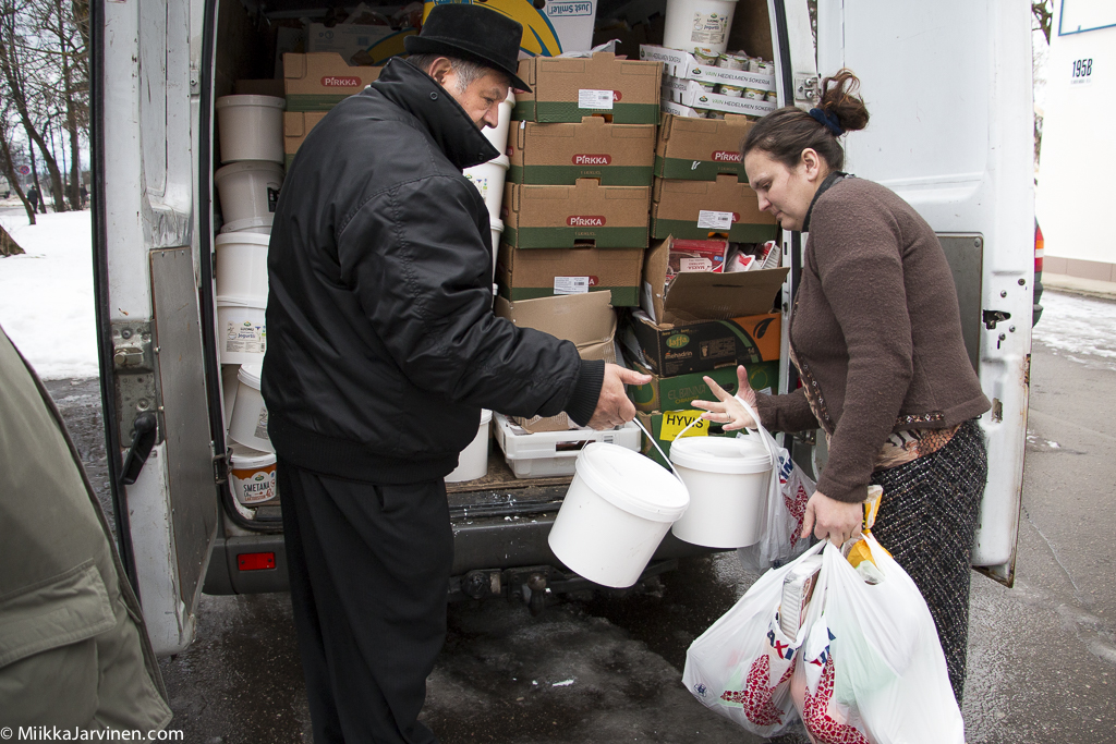 Romaniaktivisti Allan Palm jakaa ruoka-apua Latvian itärajalla.
