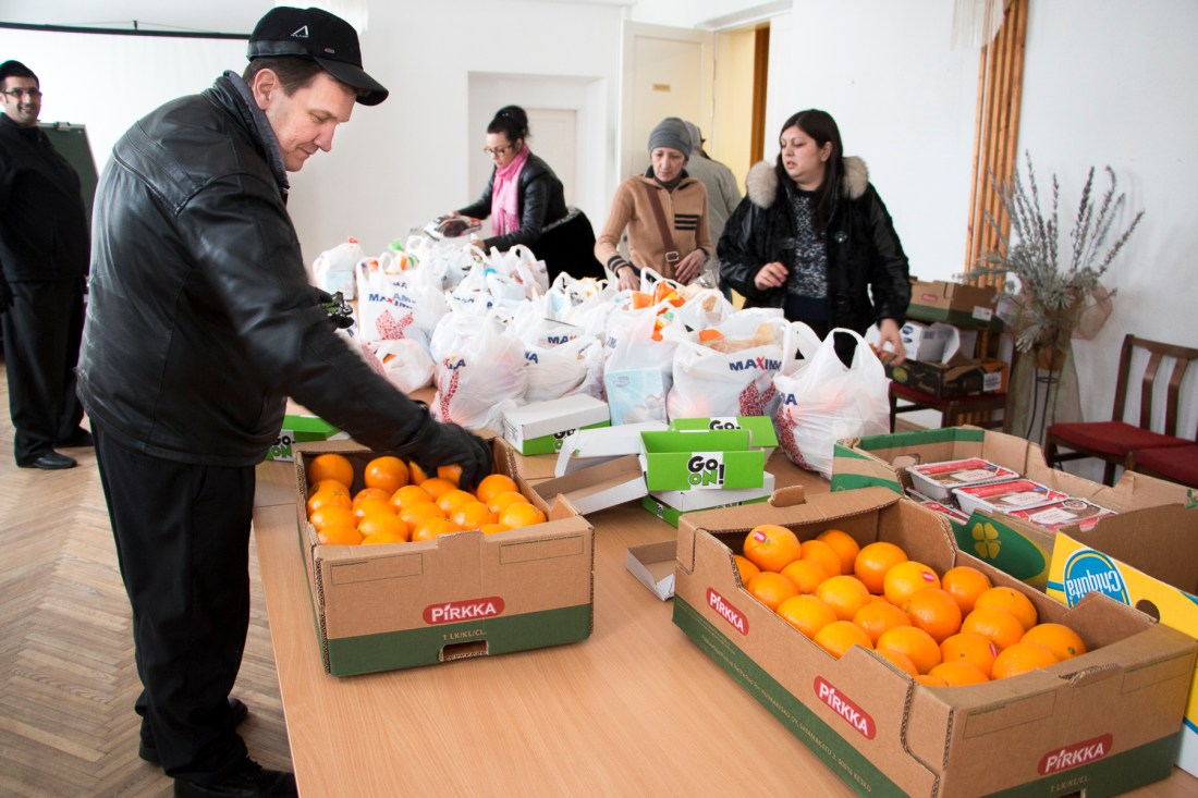 Nokialainen autokorjaamoyrittäjä Henry Koivisto järjestelee ruokajakelua latvialaisen Helluntaikirkon aulassa.