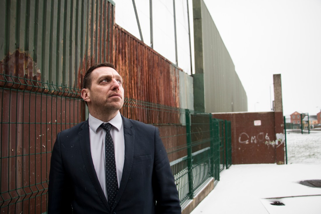 Asianajaja Padraig Ó Muirigh esittelee Belfastin katolisten ja protestanttien asuinalueita erottavaa turva-aitaa.